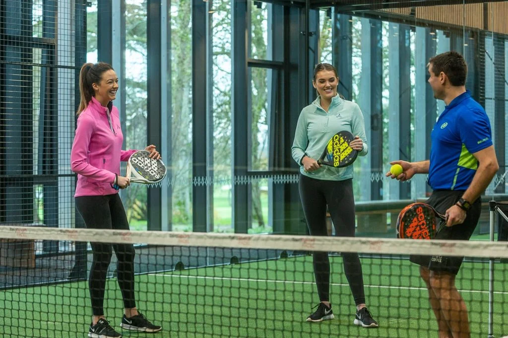 3 joueurs padel terrain hôtel vert