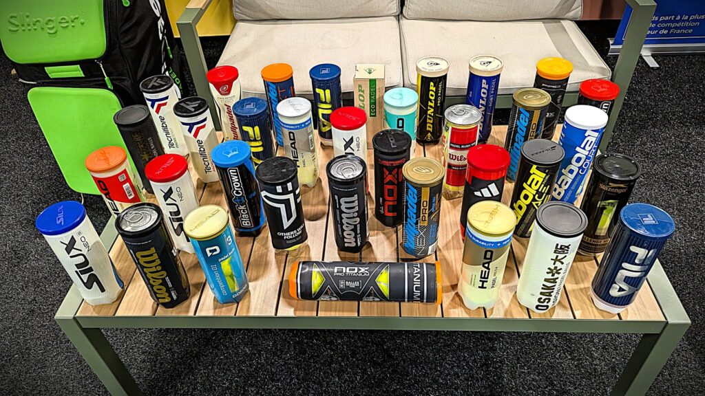 Assorted energy and nutrition cans arranged on a wooden display table in a store setting.