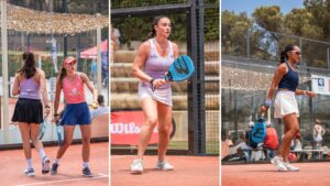 Two female padel players walk on a red outdoor court with rackets; one wears a lavender top and black skirt, the other a pink top and blue shorts (facing away).