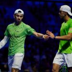 Retrouvailles explosives à Malaga Lebrón et Augsburger font tomber Galán Chingotto après un duel complètement fou | Padel Magazine Two male squash players in green shirts shake hands on a court after a match.