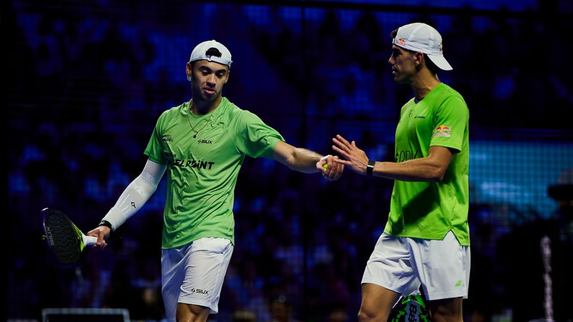 Retrouvailles explosives à Malaga Lebrón et Augsburger font tomber Galán Chingotto après un duel complètement fou | Padel Magazine Two male squash players in green shirts shake hands on a court after a match.
