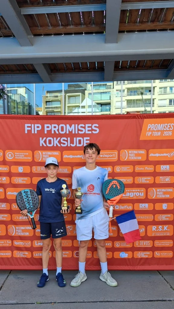 Two young players pose with trophies and paddles in front of an orange event banner at a padel tournament. A French flag is held by the player on the right.