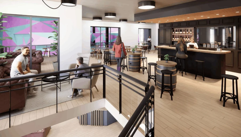 picture | Padel Magazine Modern lounge and bar area where patrons sit on stools around barrel tables, with a colorful geometric mural on glass walls in the background.