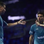 paquito di nenno malaga P1 | Padel Magazine Two male padel players in blue shirts high-fiving on a dimly lit court.