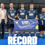Group of men and young players pose with trophies at a paddle tennis event, wearing blue jerseys with Concello de Vigo logos.