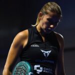 Bordeaux P2 : Collombon s'arrête en huitièmes face à une paire intouchable | Padel Magazine Female padel player in a black sleeveless top holding a teal paddle, looking down against a dark background.