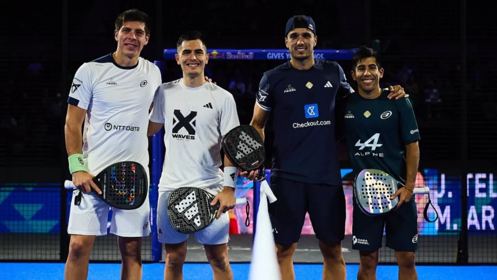 Neljä miespuolista padel-pelaajaa seisoo käsi kädessä kentällä, jokainen maila kädessään, hymyillen kameralle ottelun jälkeen.