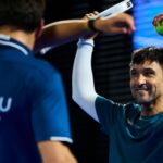 Sanyo Gutiérrez défie le temps, Tello et Arce bousculent Chingalán : le dernier carré se dessine à Pretoria | Padel Magazine Two athletes celebrate a win by high-fiving; one man in teal shirt smiles as he raises a tennis ball in his right hand. Contrasty background stadium lights behind.