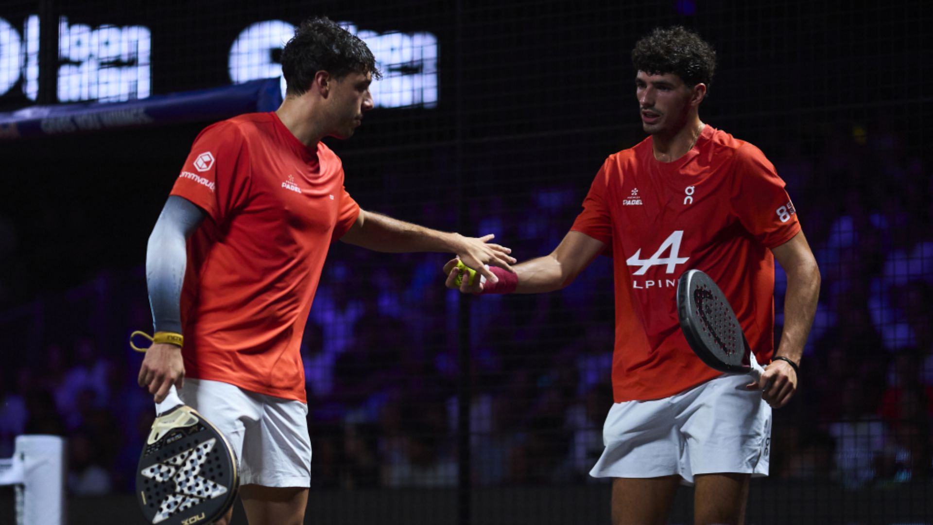 tapia coello bordeaux p2 1 | Padel Magazine Two male floorball players in red shirts high-fiving on an indoor court.