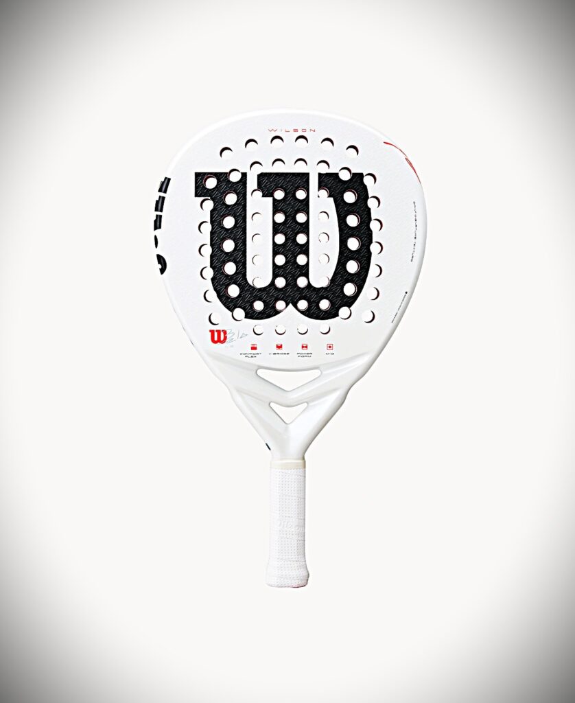 Bela LS | Padel Magazine White Wilson padel racket with a perforated black central face and a white grip, curved shape, and red Wilson logo accents.