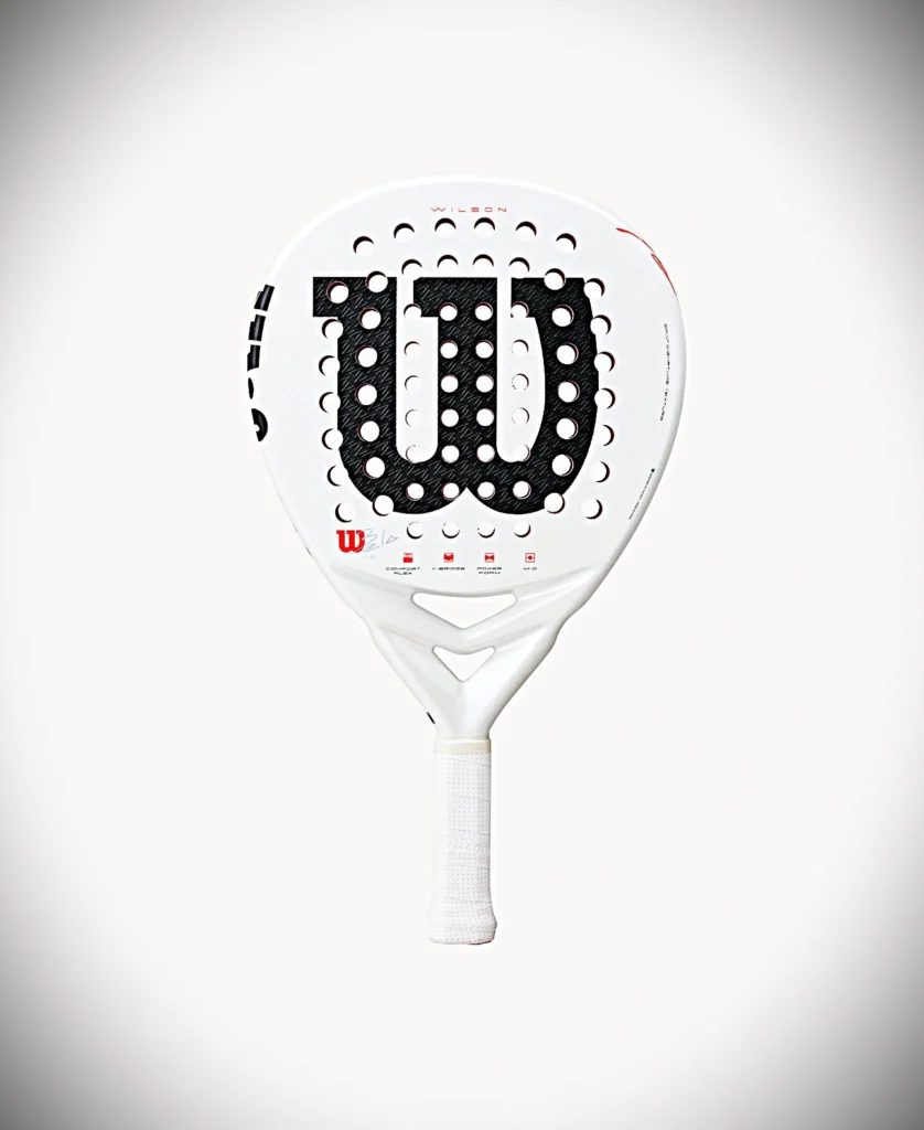 Racchetta da padel Wilson bianca con superficie centrale nera perforata e impugnatura bianca, forma curva e dettagli con logo Wilson rosso.