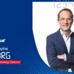 Jean-Christophe Verborg, Global Sports Marketing Director, on a blue Babolat promotional banner with logo and text.