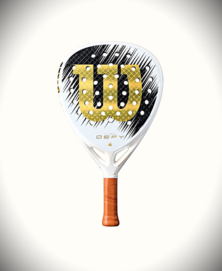White padel racket with a gold dotted U-shaped logo on the face and an orange grip, centered on a light background.