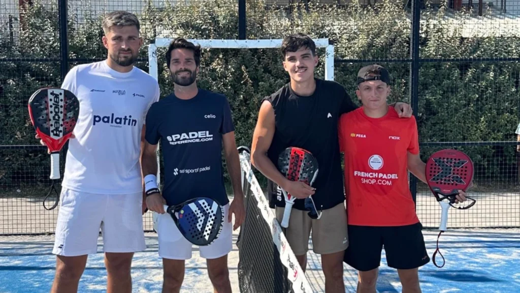 Four men posing on a padel court with paddles, wearing athletic shirts and shorts.